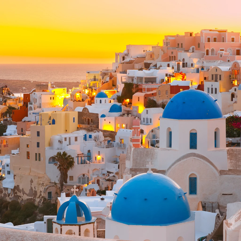 Blue-domed churches at sunset in Oia, Santorini, Greece