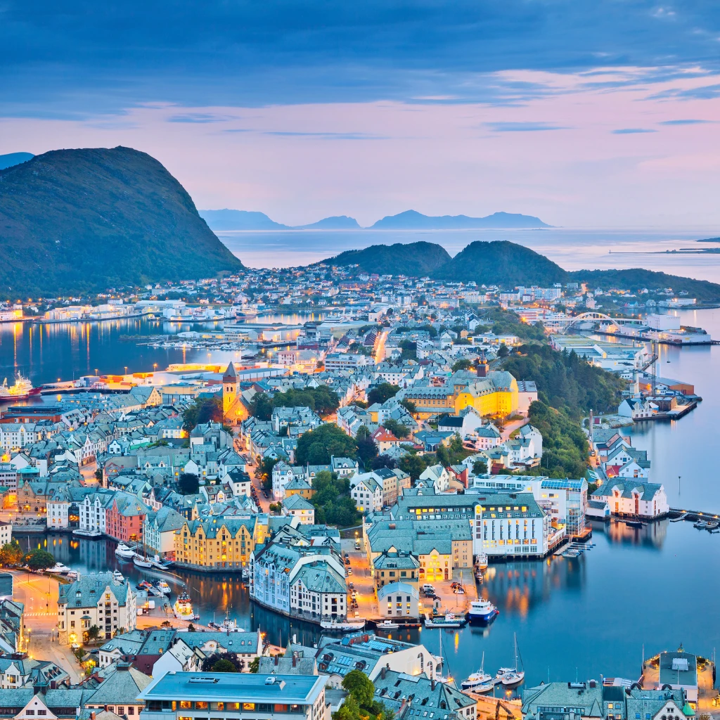 Alesund, Norway harbour at blue hour with fjord mountains